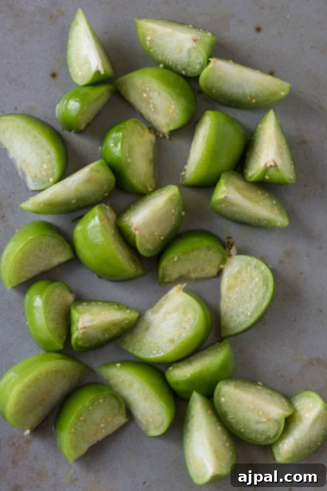 Smoky Chipotle Blaze 7 Freshly quartered tomatillos sit on a cutting board, waiting to be roasted as a key component of the homemade Chipotle Hot Salsa.