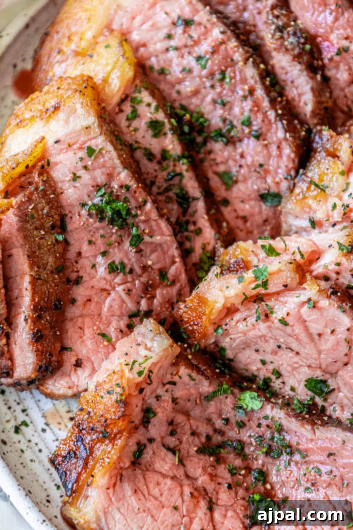 Sliced Bottom Round Roast on a plate, showcasing its tender texture and juicy interior.