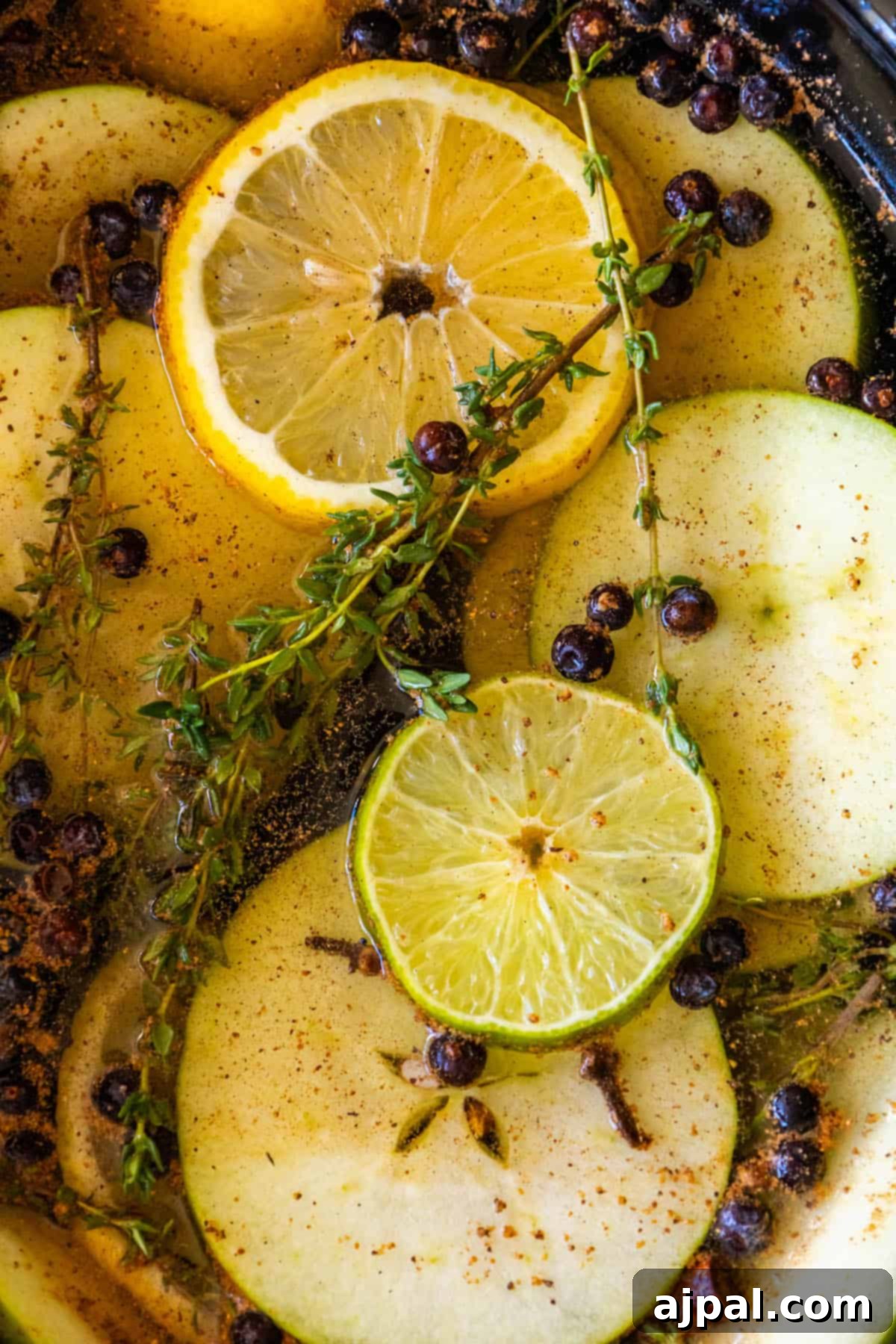 Slow Cooker Christmas Potpourri 2 A croc containing apples, lemons and sprigs of thyme.