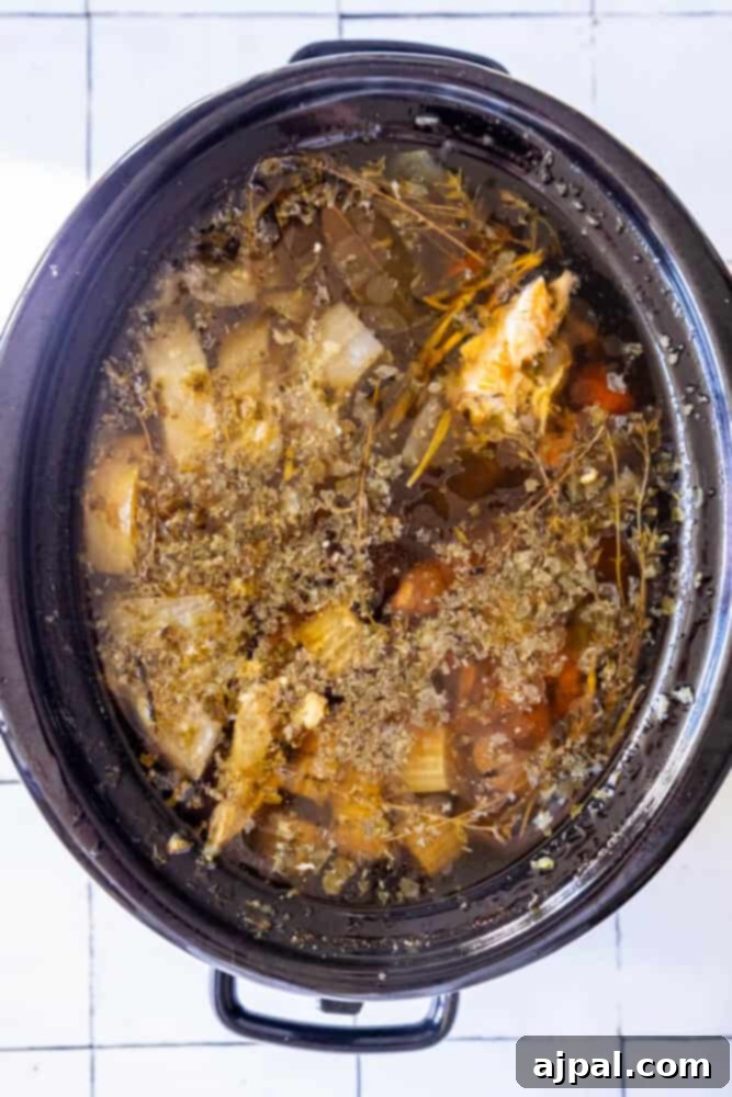 Slow Cooker Christmas Potpourri 5 A crock pot filled with vegetables and herbs, creating a delightful holiday potpourri.