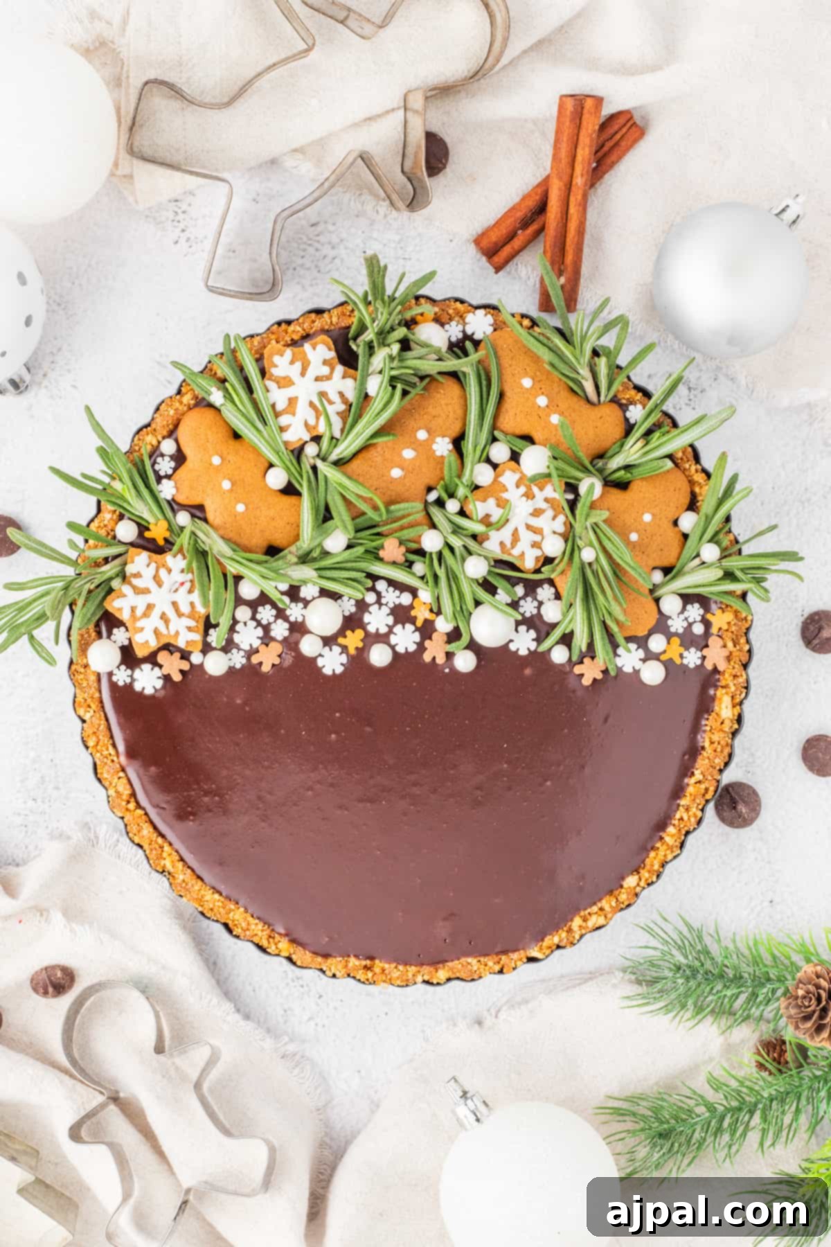 A beautifully decorated gingerbread chocolate tart, adorned with festive ornaments, perfect for holiday celebrations.