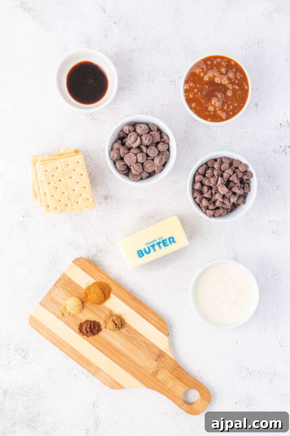 A wooden cutting board with a beautifully arranged assortment of gingerbread and chocolate ingredients on it, ready for baking.