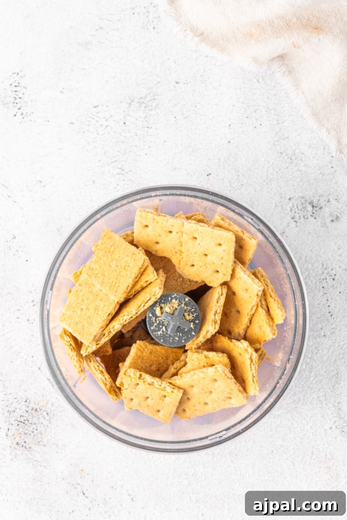 Graham crackers in a bowl on a white surface, destined to become the flavorful crust for our gingerbread tart.