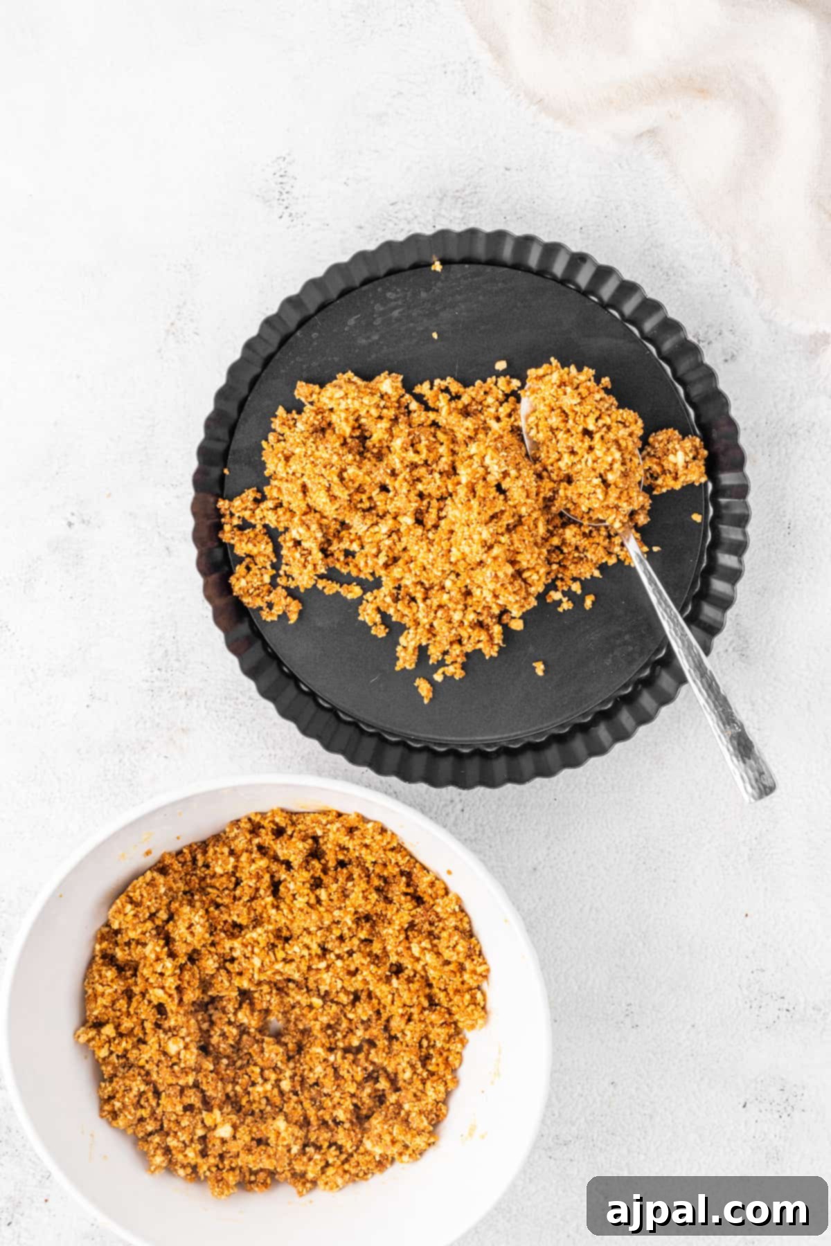 A bowl of gingerbread granola with a spoon next to it, hinting at the warm spice flavors used in the tart.