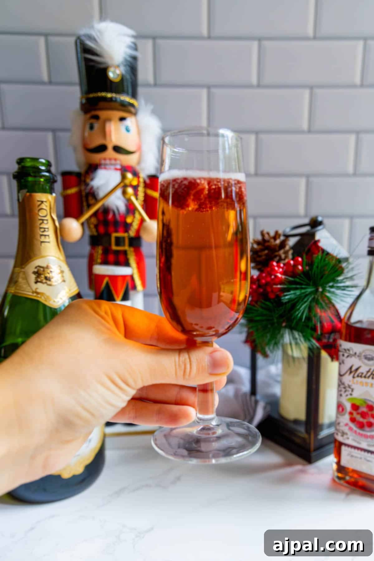 Raspberry Champagne Glow 2 A glass of mulled wine with a nutcracker in the background, accompanied by a raspberry sparkler, suggesting festive cheer.