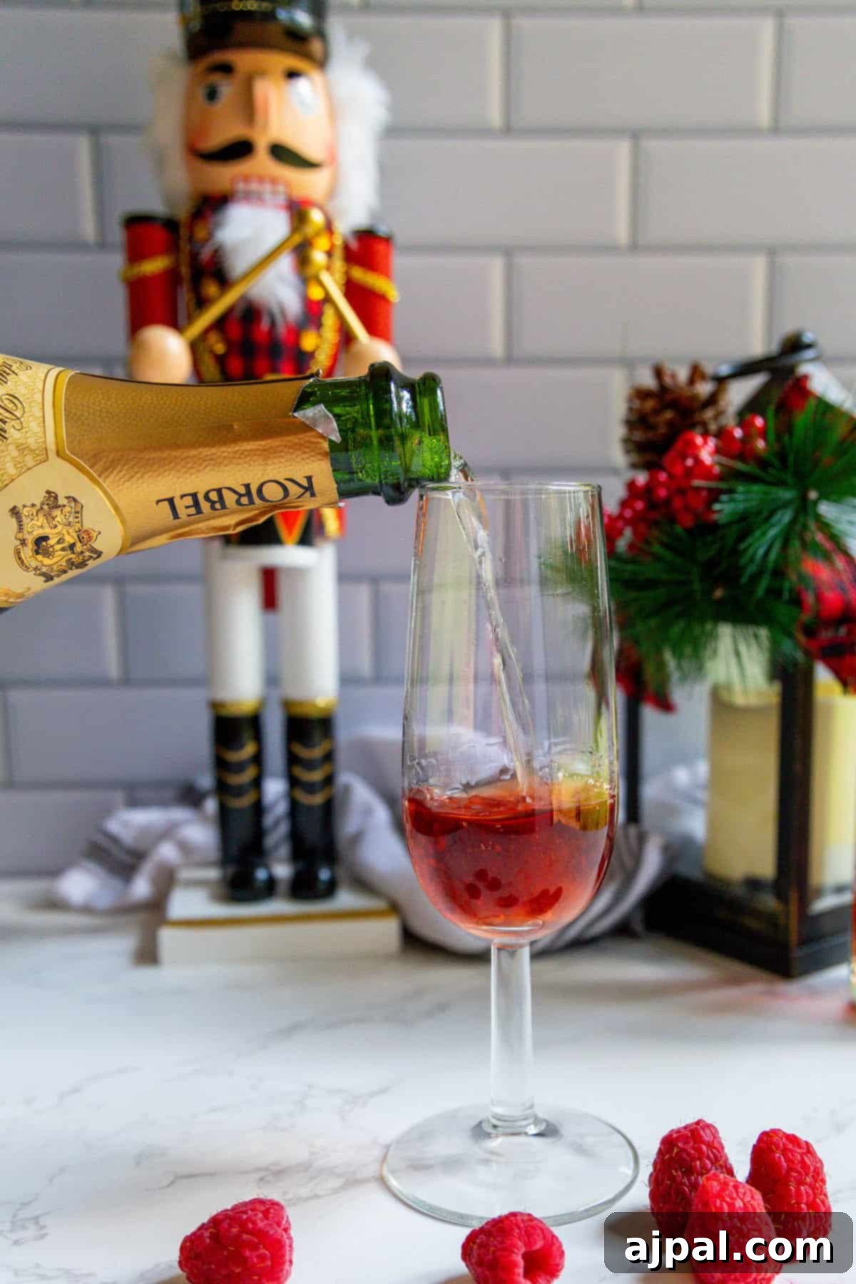 Raspberry Champagne Glow 5 A raspberry champagne sparkler is being expertly poured into a glass, highlighting the delicate bubbles and vibrant color of the drink.