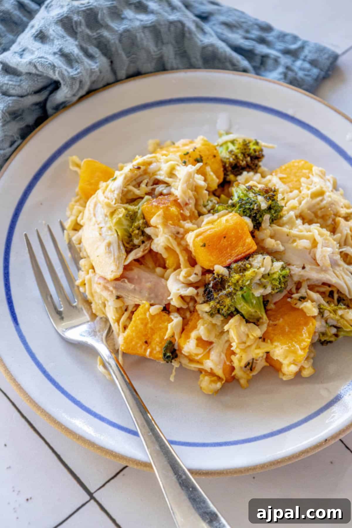 A plate with golden chicken, vibrant broccoli, and creamy rice from a butternut squash casserole.
