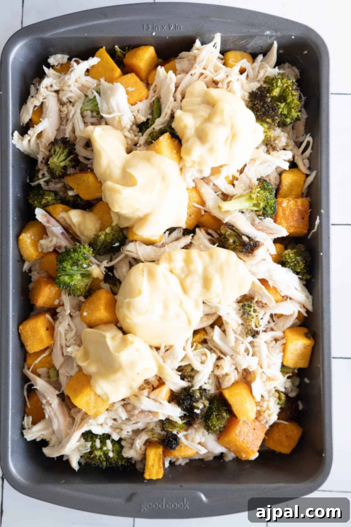 A casserole dish with chicken, broccoli, and butternut squash, ready to be served.