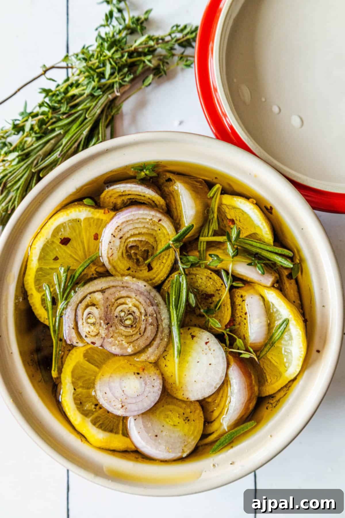 A shallow bowl showcasing luscious confit onions, enhanced with fresh sprigs of thyme, inviting a taste of its aromatic goodness.