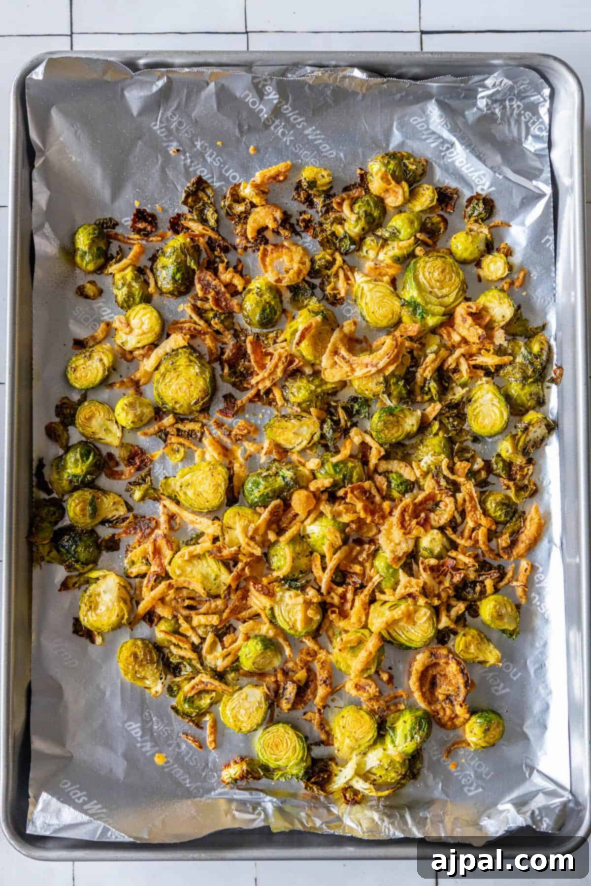 Caramelized Brussels Sprouts and Sweet Onions 6 Roasted brussels sprouts on a baking sheet with onions.
