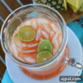 A pitcher of pineapple limeade with lime slices and Rum Punch.