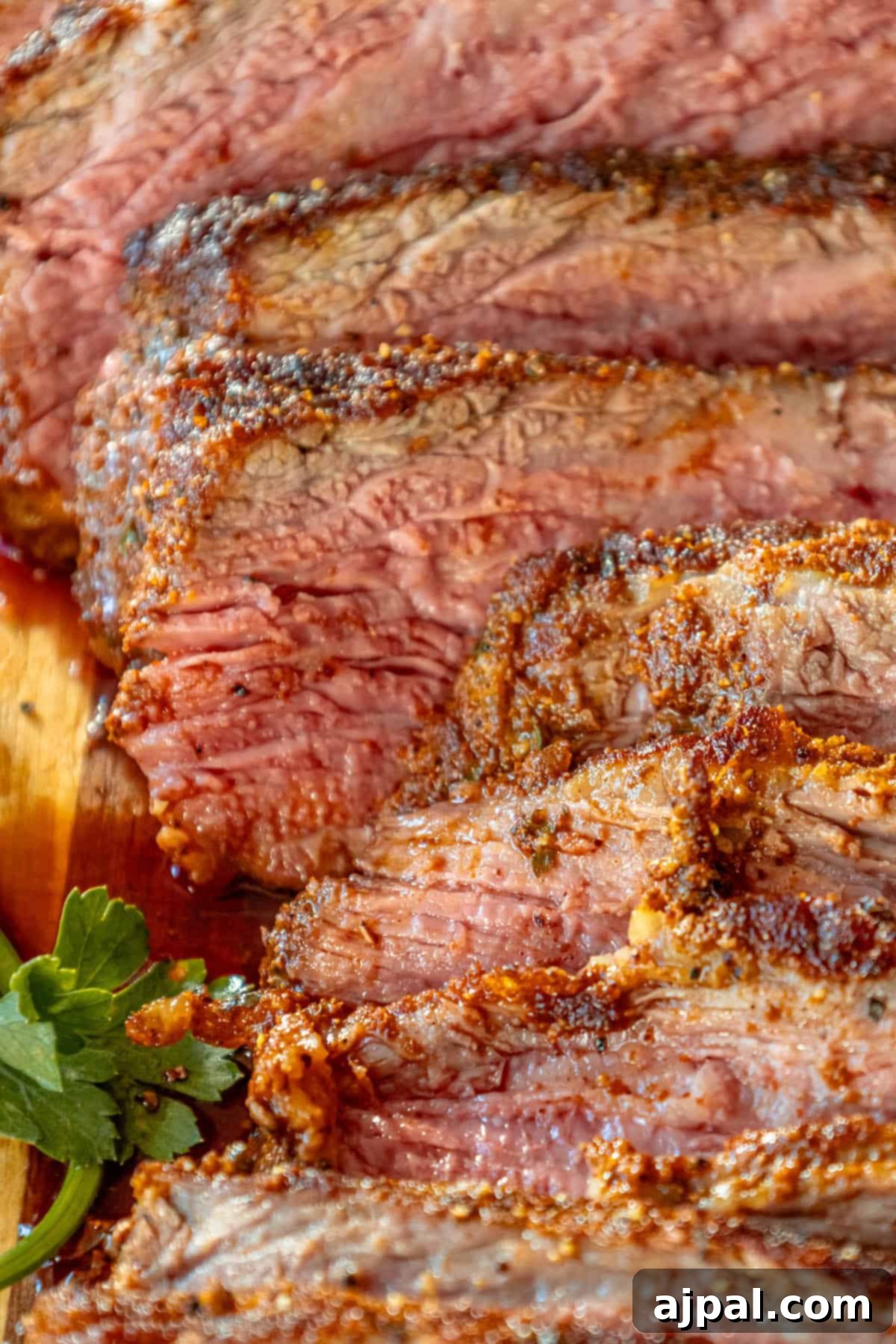 A reverse seared flank steak on a cutting board.