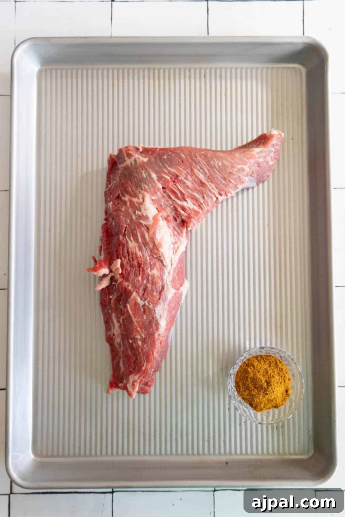 A reverse seared tri-tip steak on a baking sheet.