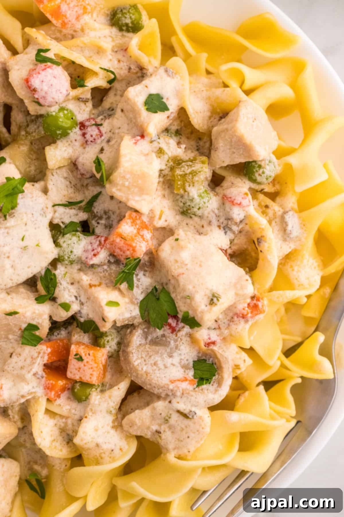 Easy Slow Cooker Chicken a la King 11 A slow cooker dish featuring tender chicken and freshly cut vegetables served over a bed of pasta.