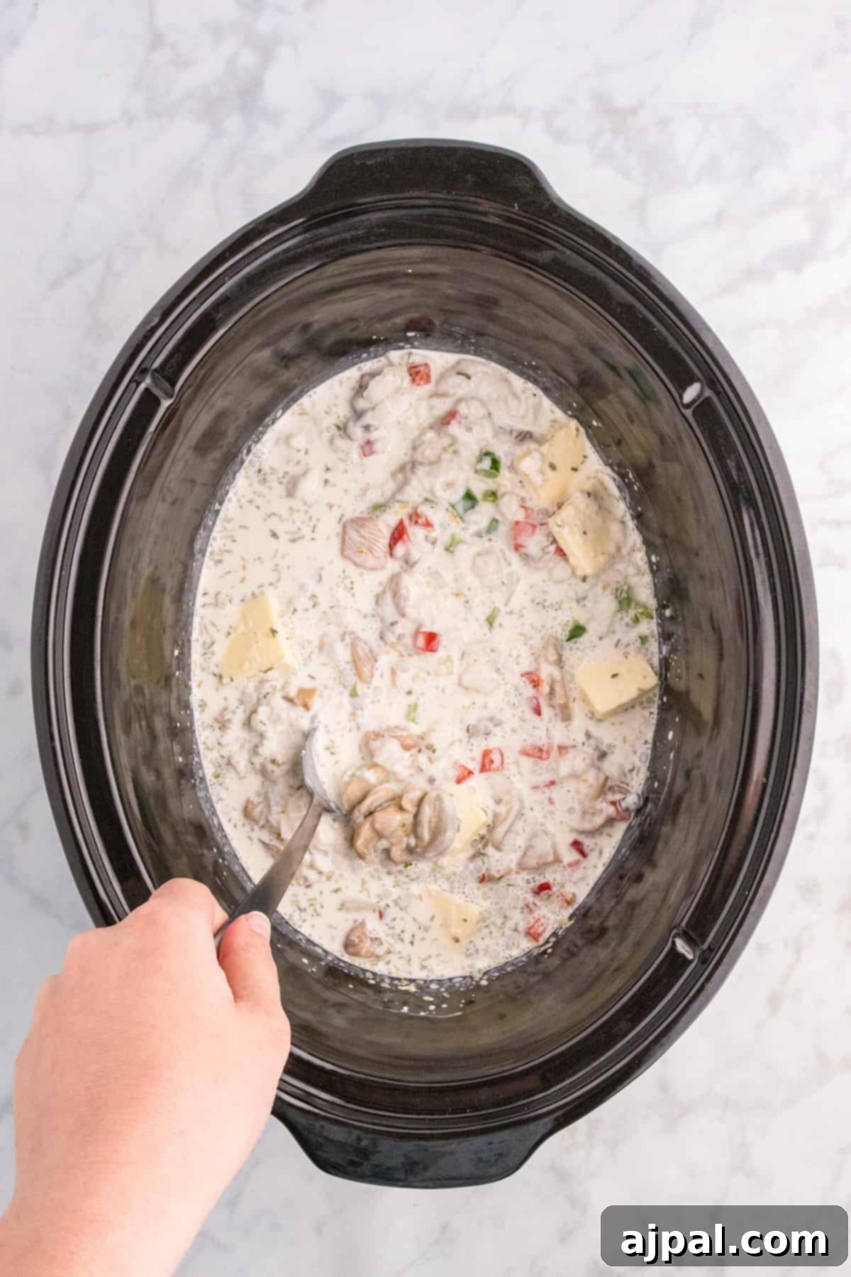 Easy Slow Cooker Chicken a la King 8 A person pouring Chicken a la King soup into a slow cooker crock pot.