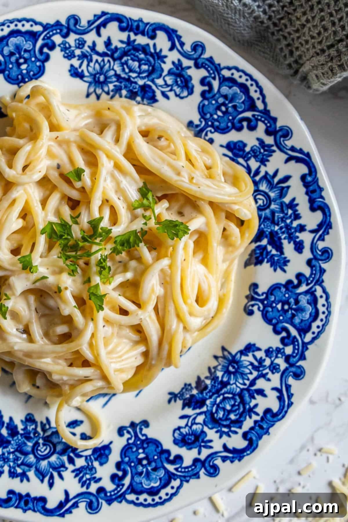 Indulgent Alfredo Perfection 2 A delicious plate of pasta generously smothered in velvety Alfredo sauce, adorned with freshly grated Parmesan cheese and a delicate sprinkle of fragrant parsley, capturing the essence of comforting homemade cuisine.