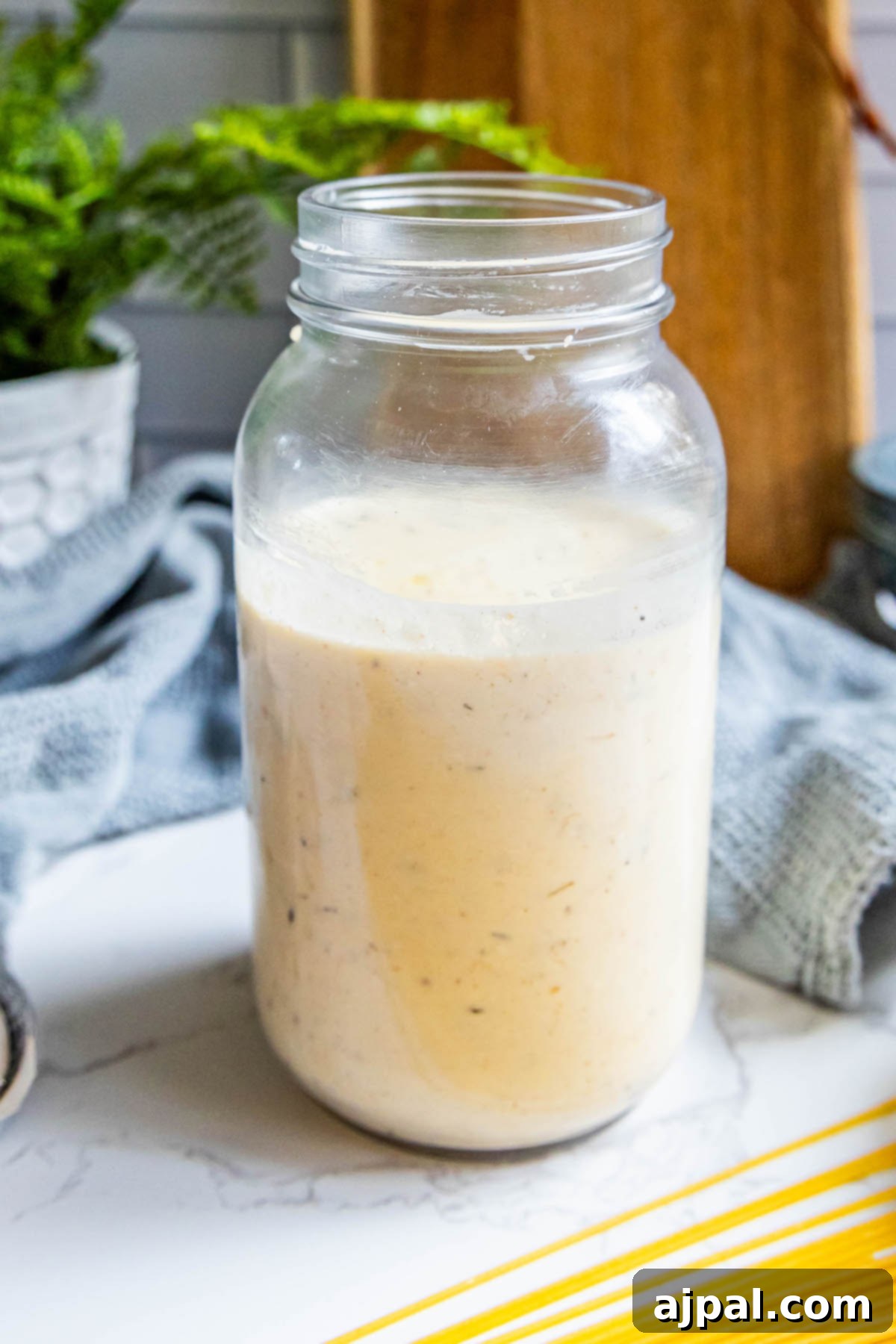 Indulgent Alfredo Perfection 11 A rustic mason jar brimmed with the luscious, homemade Alfredo sauce, perfectly positioned on a countertop, ready to infuse any meal with its creamy goodness.