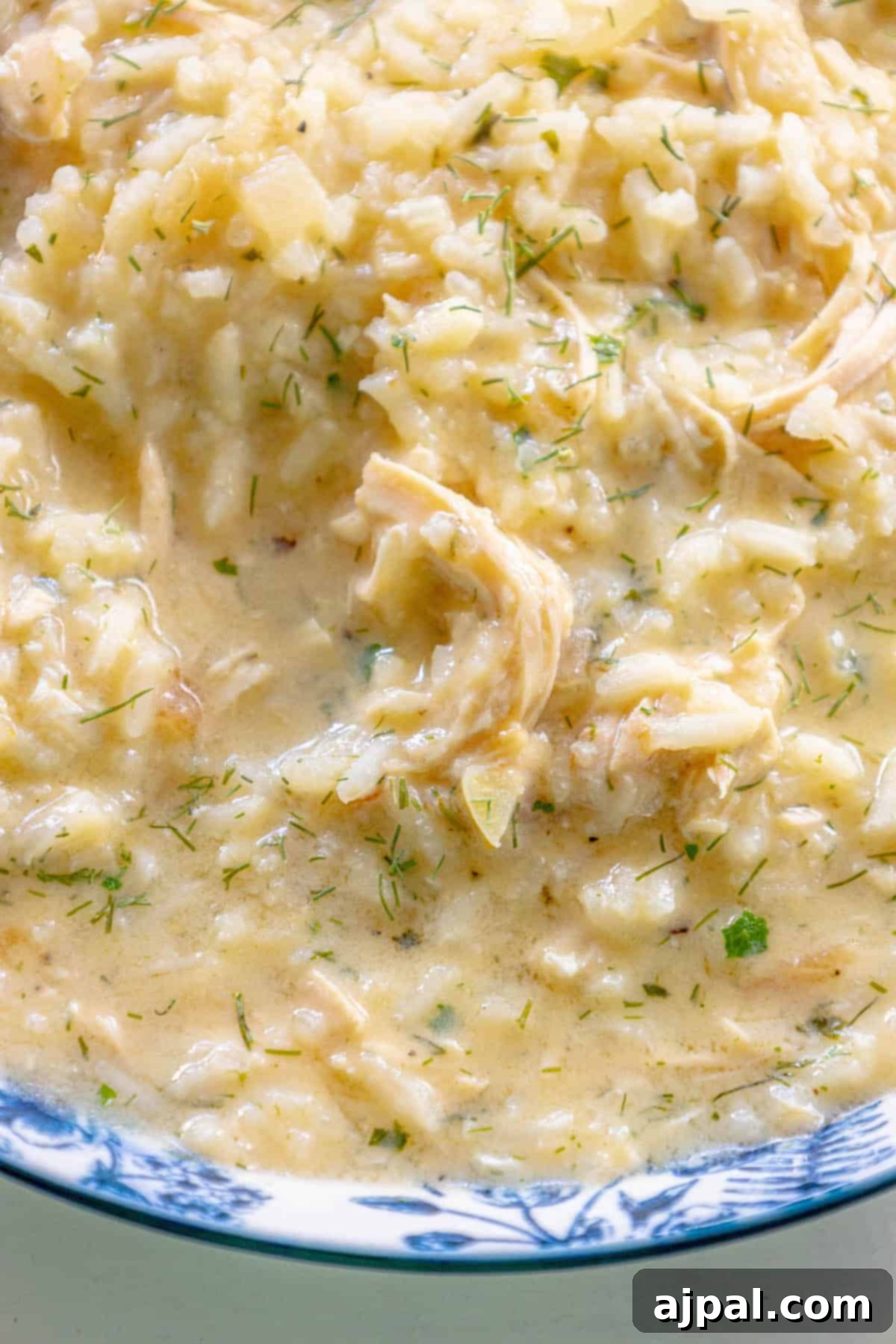 Velvety Greek Avgolemono 6 Greek chicken risotto in a blue and white bowl.