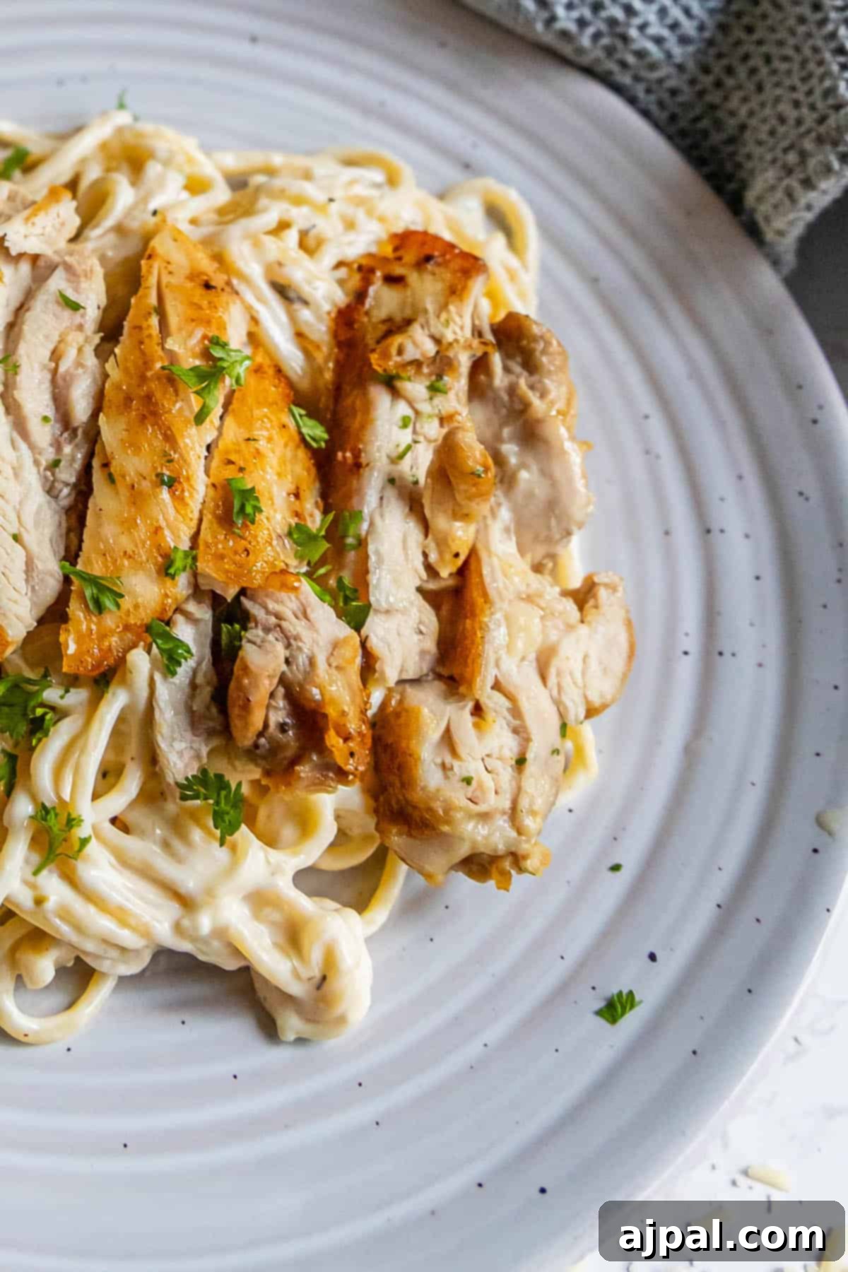 Creamy Chicken Alfredo Perfection 2 Chicken parmigiana on a white plate.