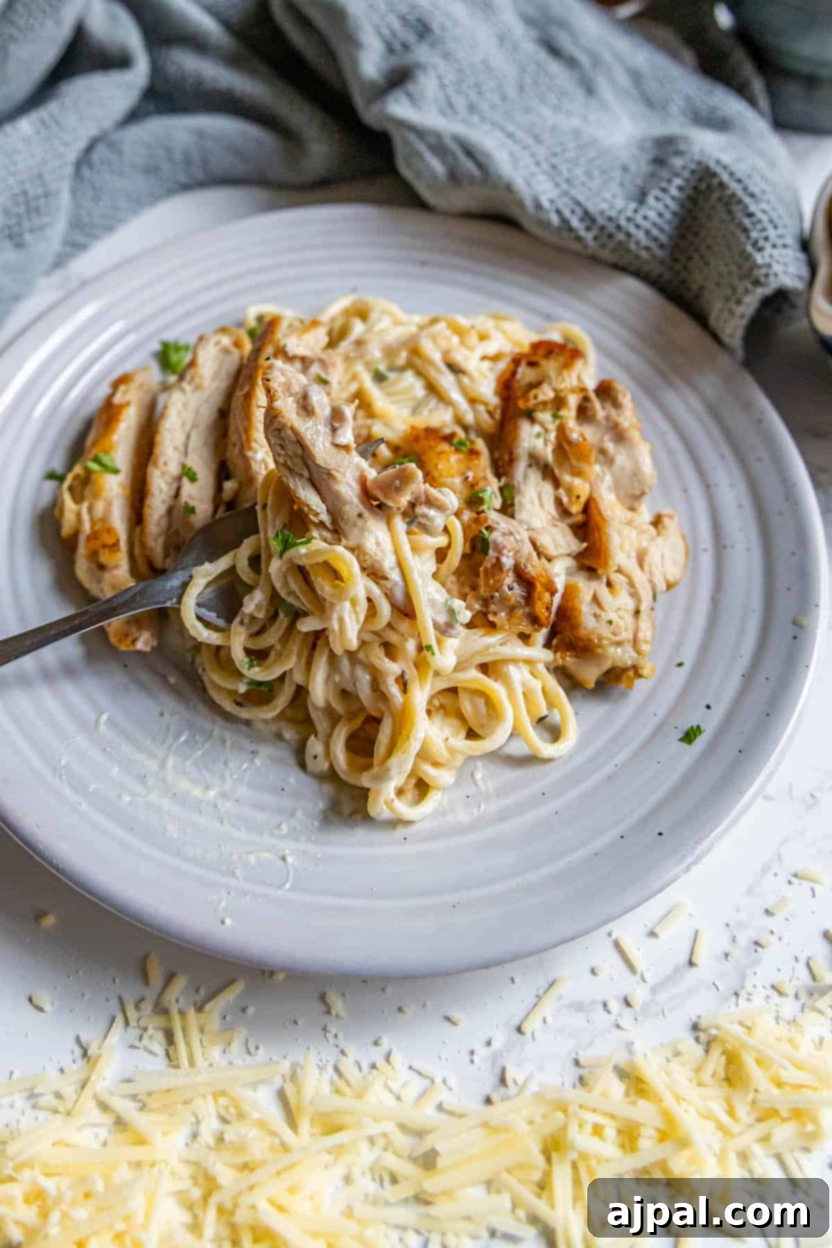 Creamy Chicken Alfredo Perfection 4 A plate of pasta with chicken and cheese on it.