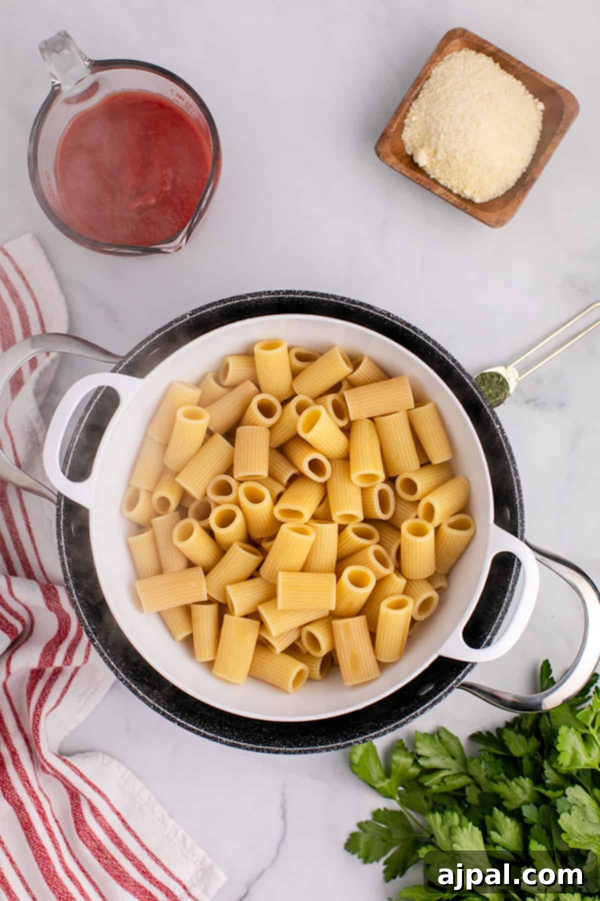 Spicy rigatoni pasta in a pan with sauce and parsley, ready to serve.