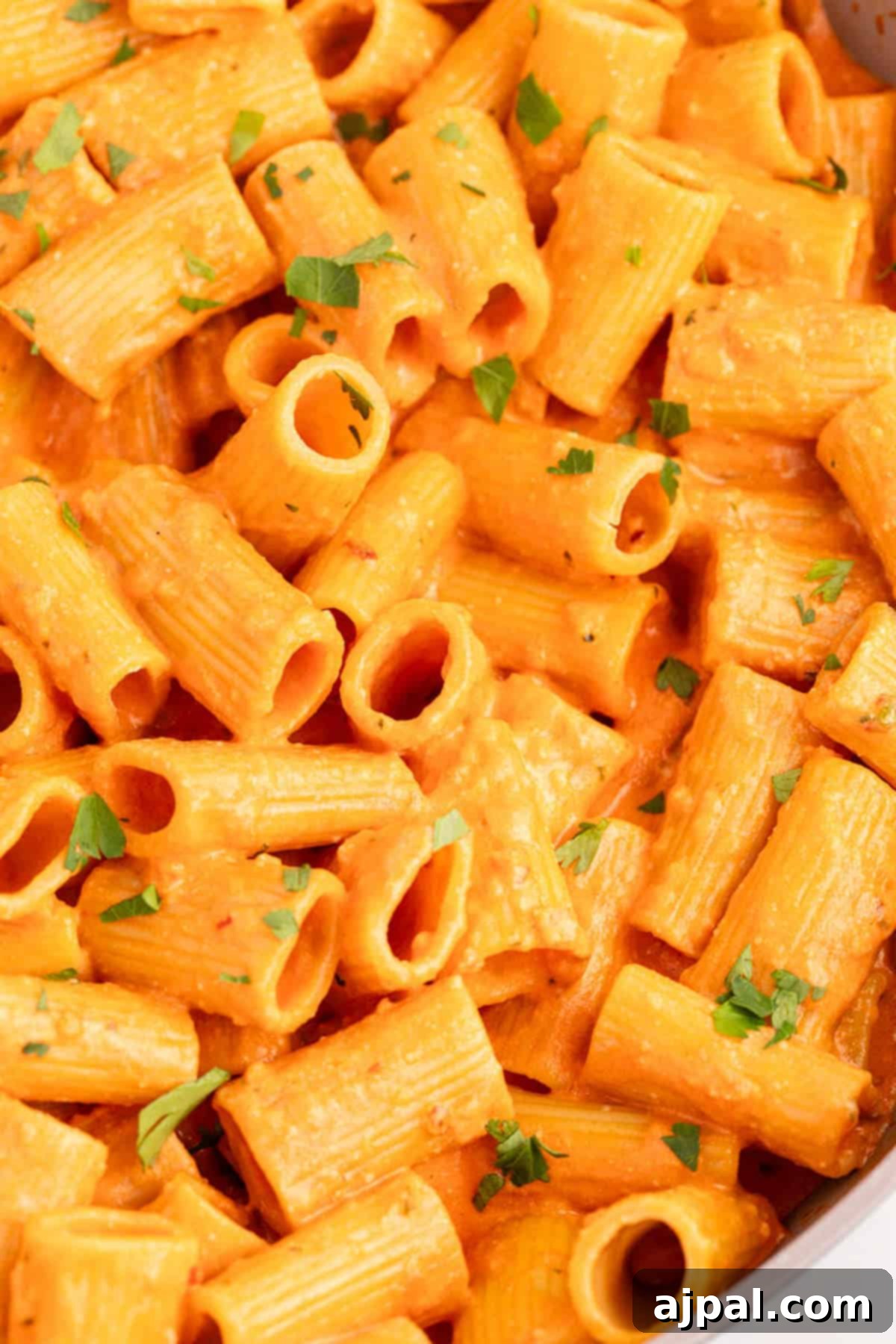 A pan full of Spicy Rigatoni Pasta simmering in a rich sauce.