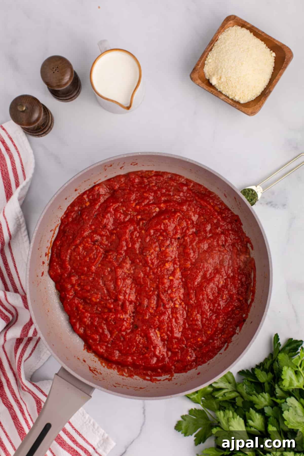 A spicy frying pan filled with simmering tomato sauce.