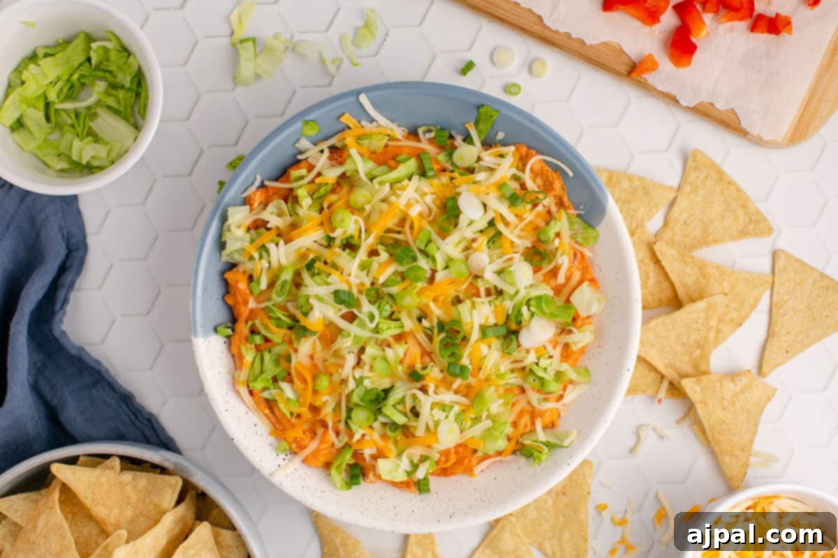 Zesty Taco Dip 4 A close-up of a rich, bubbling hot taco dip served in a bowl, garnished with shredded cheese and fresh cilantro.