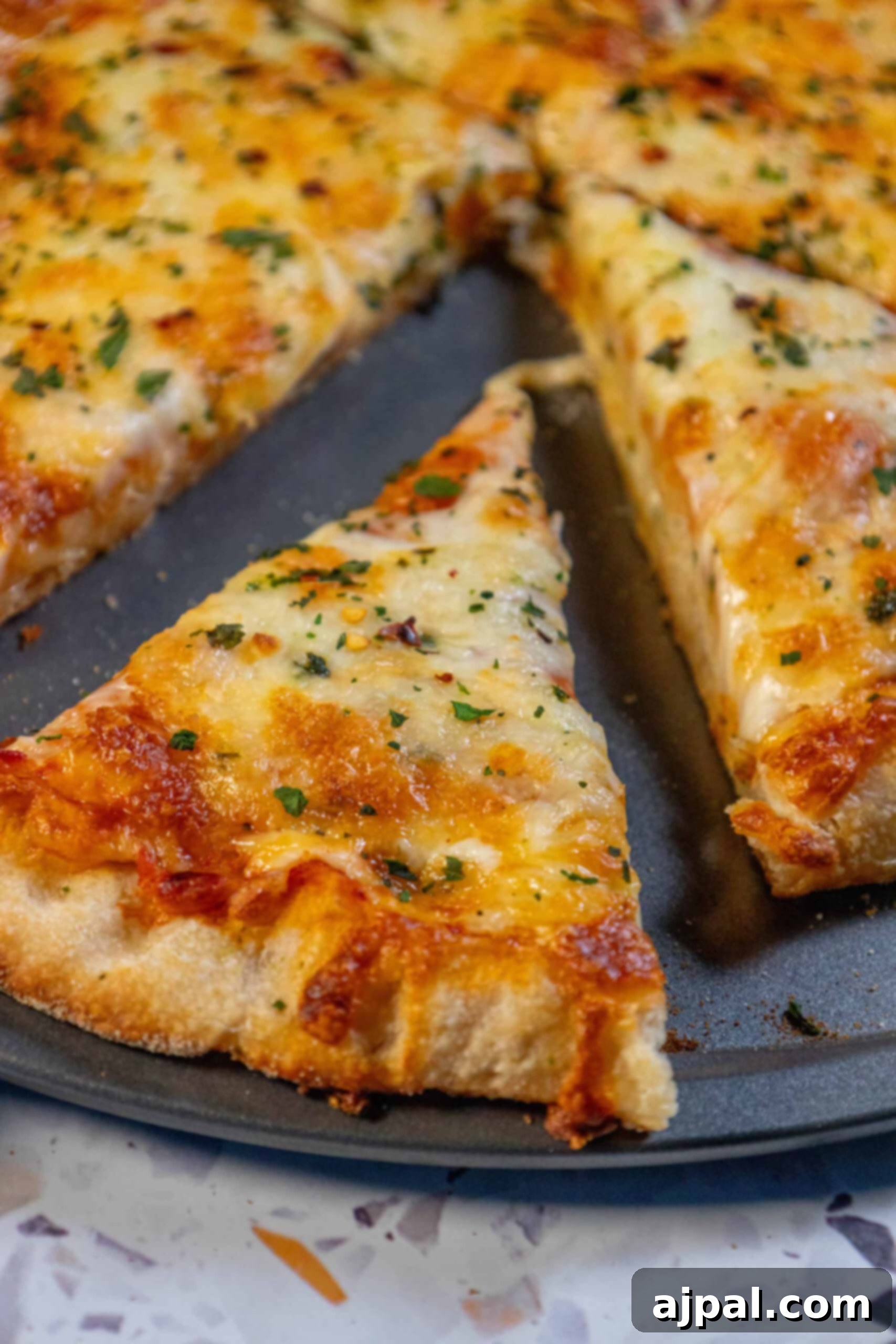 An easy homemade pizza on a pan with a perfect slice removed, ready for serving.