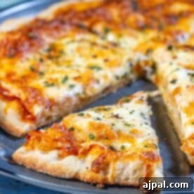 An easy homemade pizza with cheese and herbs on a plate.