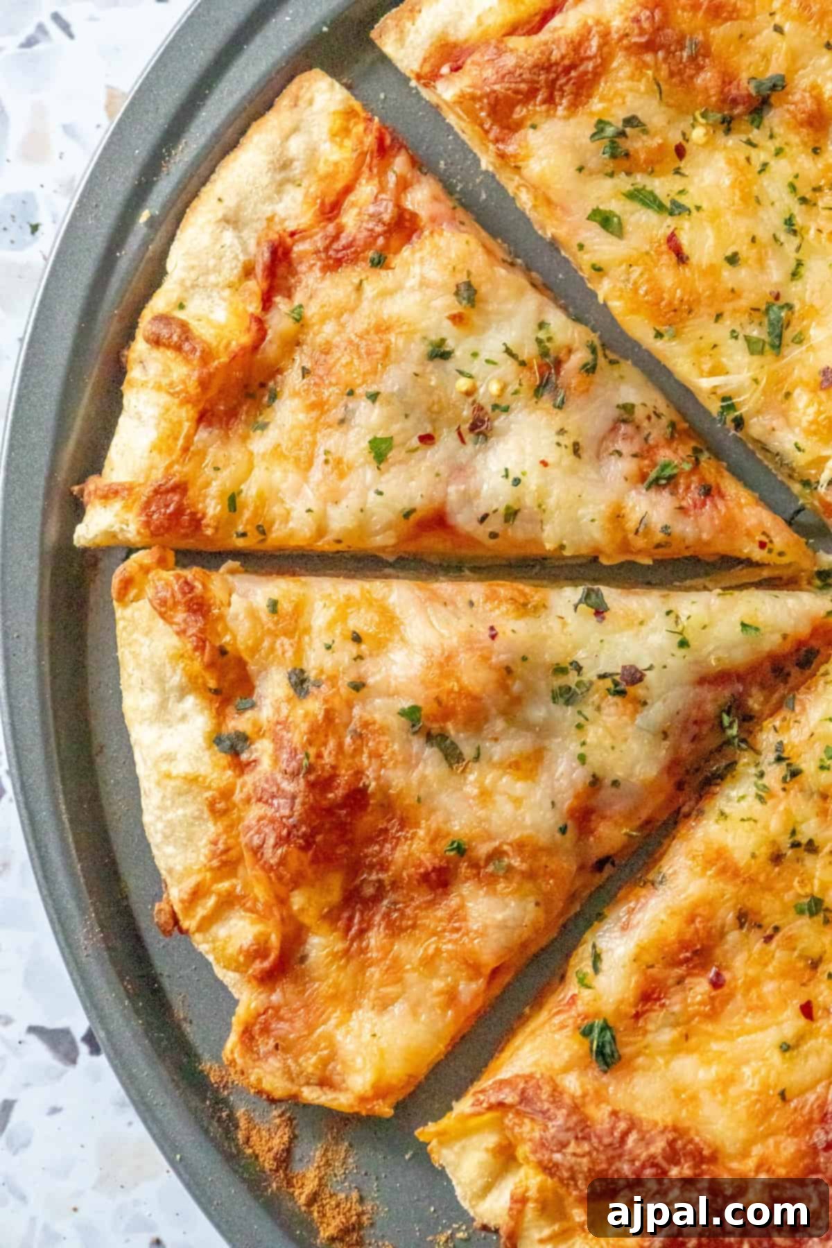 A delicious slice of easy homemade cheese pizza, perfectly golden and melted, on a white plate.