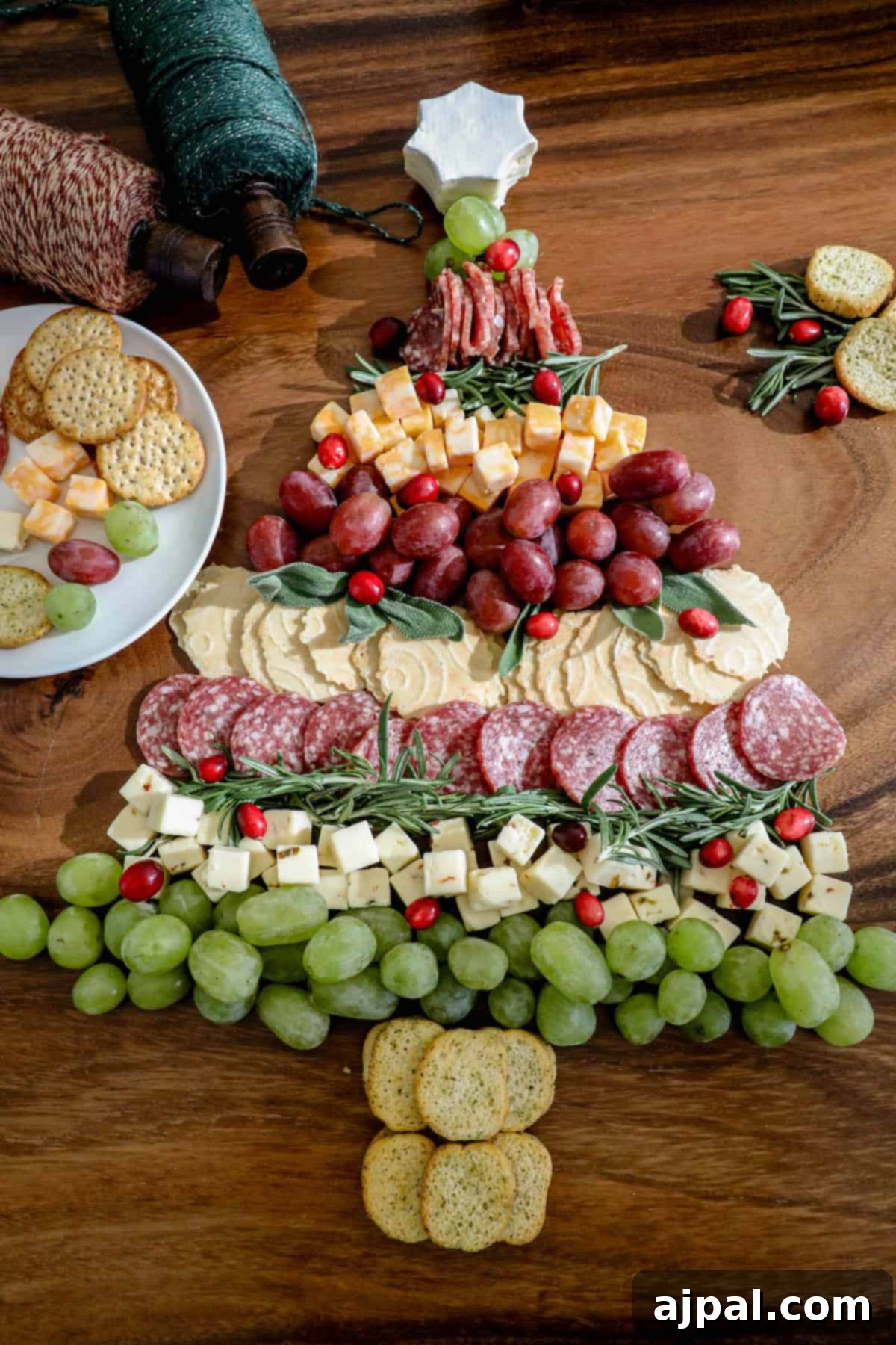 A christmas tree made of cheese, crackers and grapes.