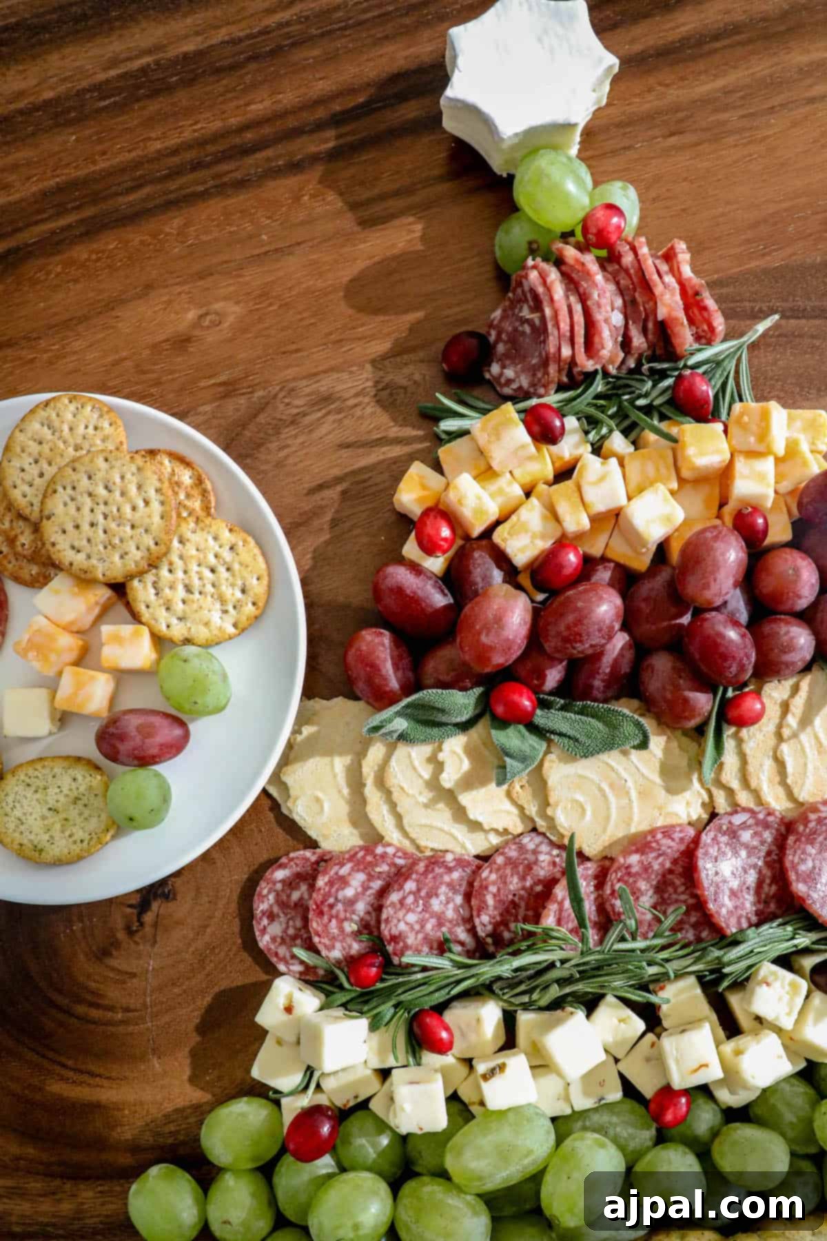 A christmas tree made of cheese, crackers and grapes.