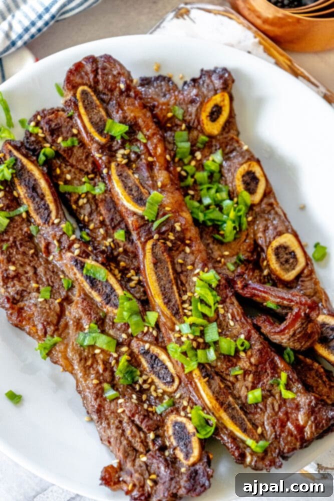 Korean BBQ Galbi Flanken Ribs 2 Sizzling Korean grilled flanken ribs, garnished with vibrant green onions and toasted sesame seeds, resting on a pristine white plate atop a rustic wooden table.