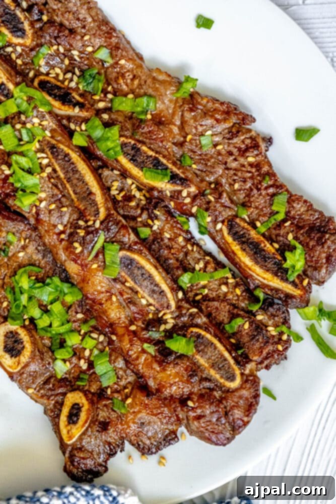 Korean BBQ Galbi Flanken Ribs 7 Korean beef ribs with sesame seeds on a plate.