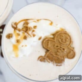 A gingerbread latte with whipped cream and a gingerbread man.