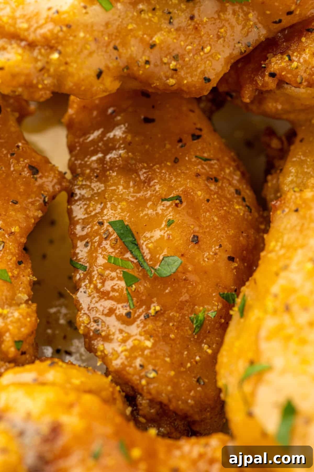 A captivating close-up of lemon-infused chicken wings, generously sprinkled with cracked black pepper, artfully arranged on a plate.