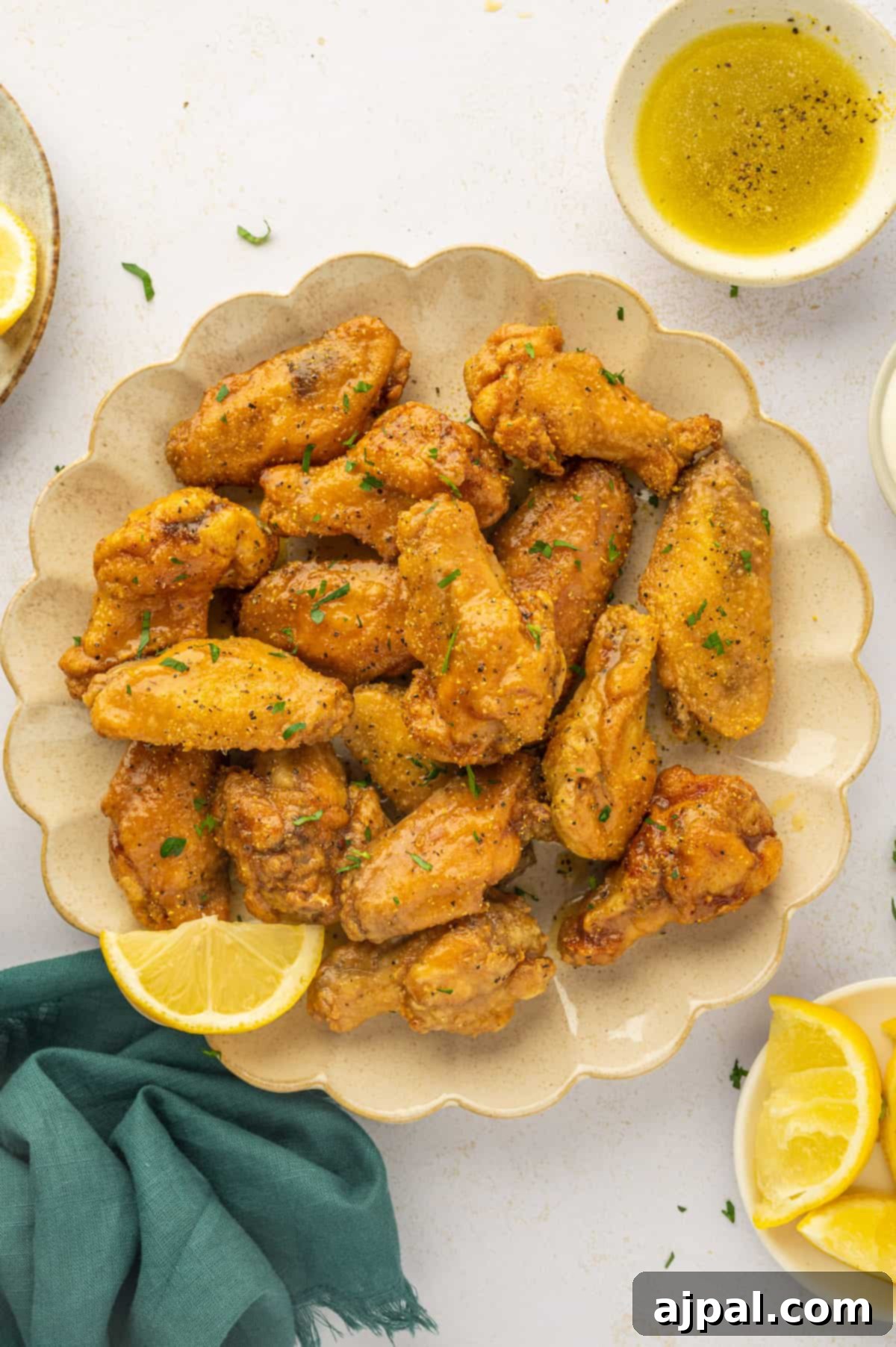 A vibrant plate of golden lemon pepper chicken wings, garnished with fresh herbs, showcasing their crispy texture.