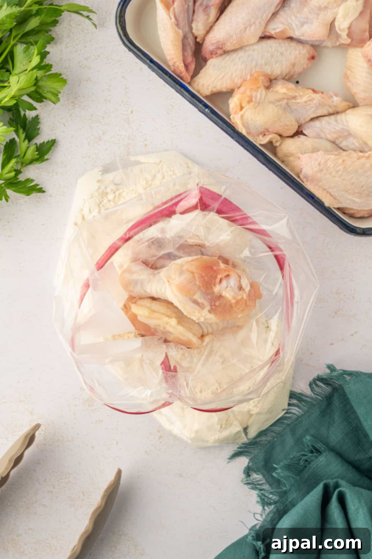 Chicken wings and flour mixture tossed together in a plastic bag for even coating.
