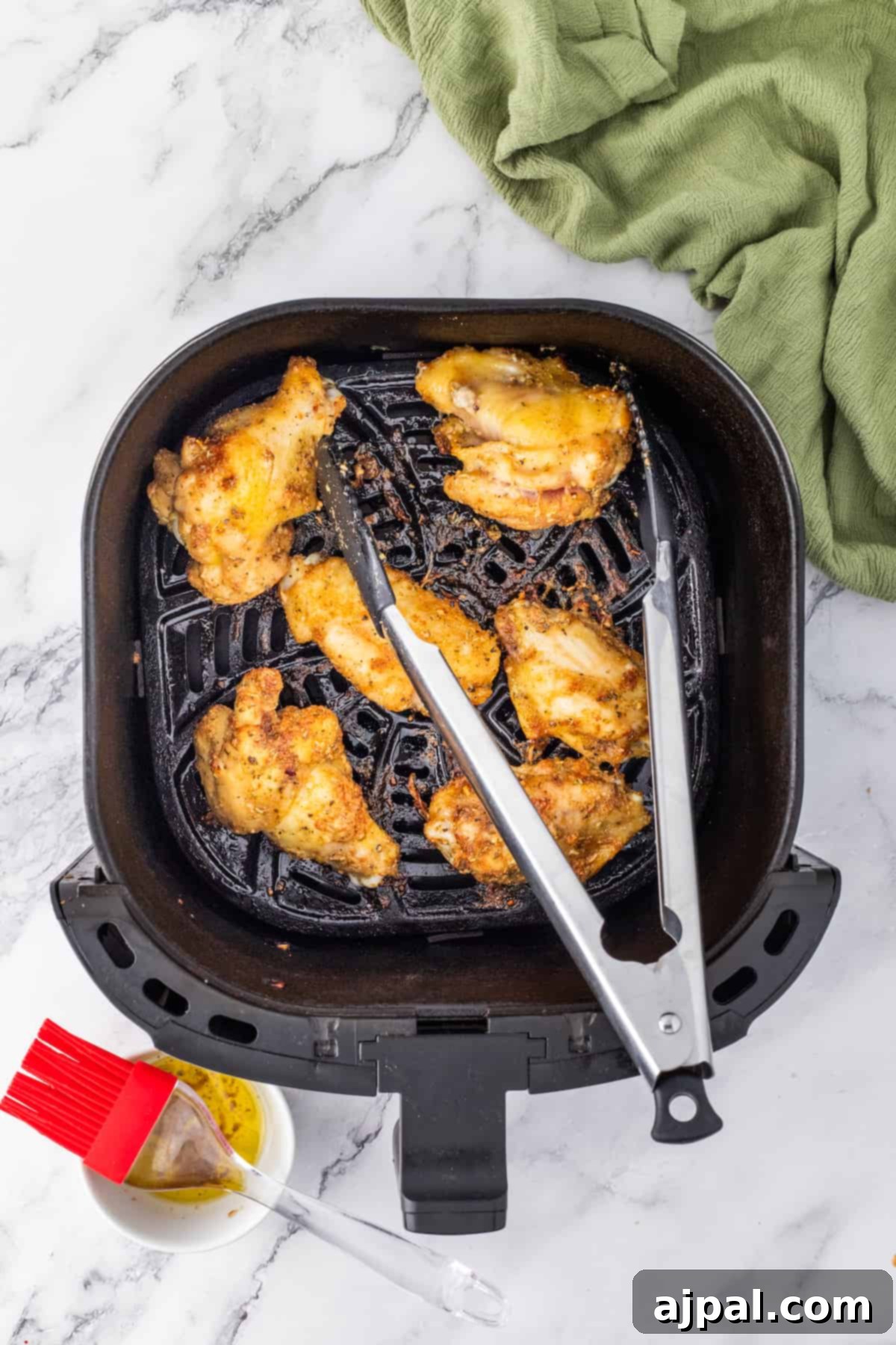 Crispy Air-Fried Wings 9 Chicken wings cooked effortlessly in an air fryer on a sleek marble countertop.