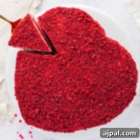A Red Velvet Cake in the shape of a heart, beautifully frosted and presented on a white plate, capturing its festive and romantic appeal.