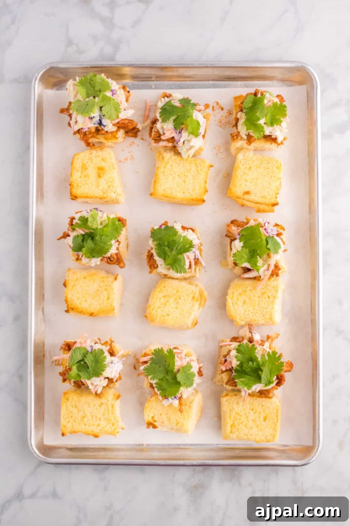 Smoky BBQ Chicken Minis 8 A vibrant tray of BBQ chicken sliders, perfectly arranged on a sleek marble table, ready to be enjoyed.