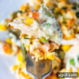 A fork is holding a creamy chicken casserole.