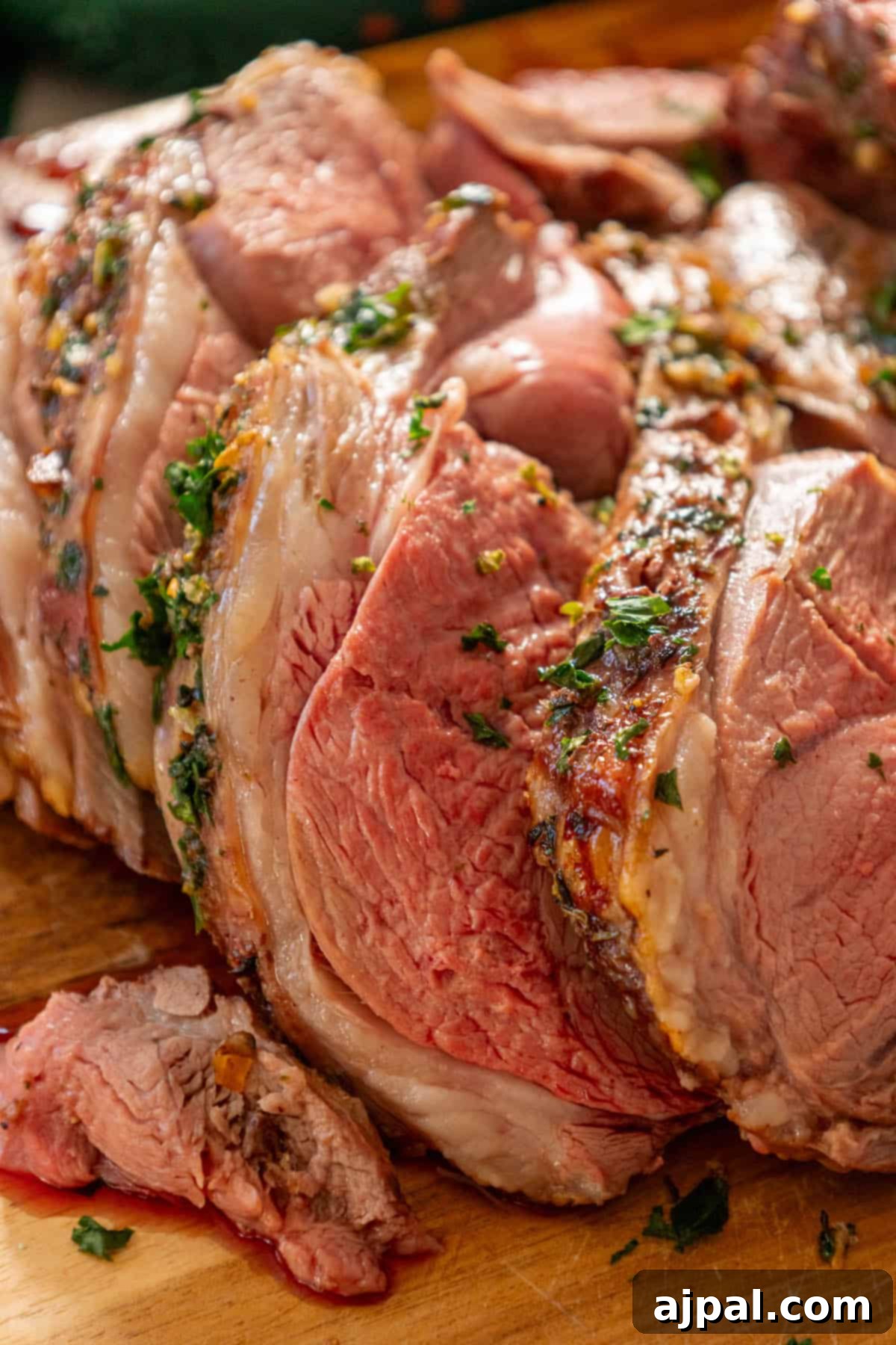 Succulent Reverse Seared Lamb Leg 2 A beautifully cooked, juicy Reverse Seared Leg of Lamb resting on a rustic wooden cutting board, ready to be carved and served.