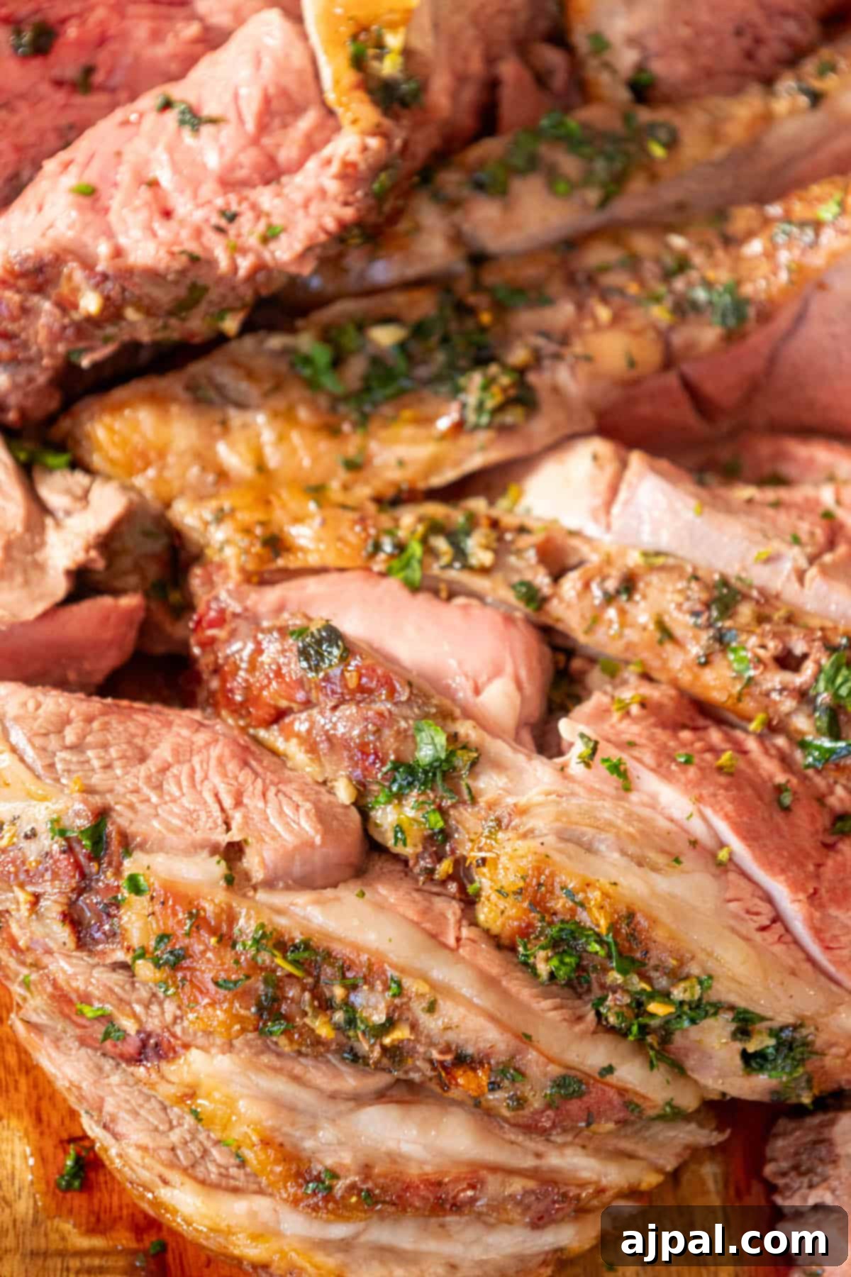 Succulent Reverse Seared Lamb Leg 11 Delicious slices of Reverse Seared Leg of Lamb arranged on a wooden cutting board, ready to be served.