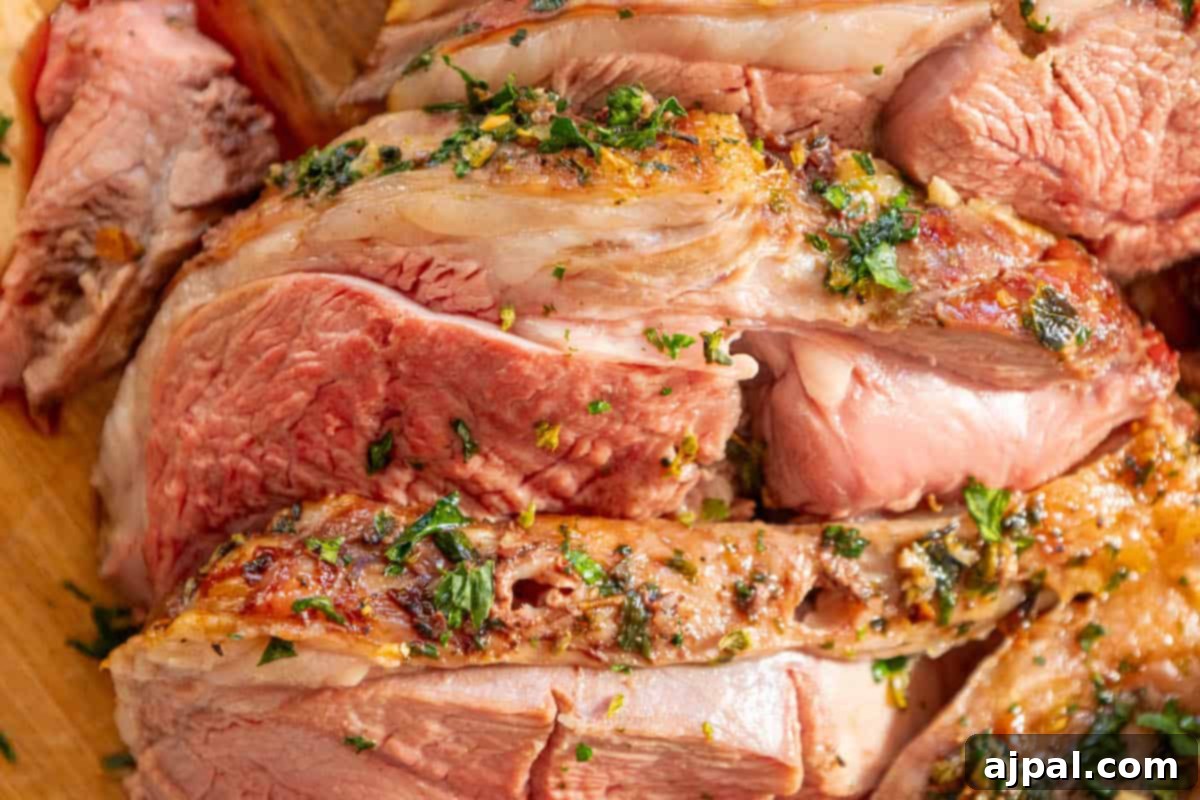 Succulent Reverse Seared Lamb Leg 12 A reverse seared leg of lamb with herbs on a wooden cutting board, beautifully presented.