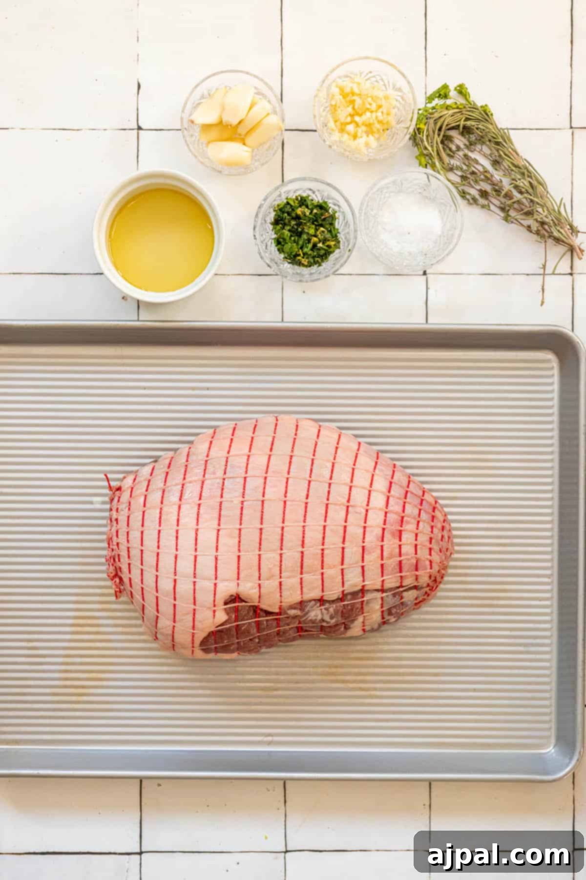 Succulent Reverse Seared Lamb Leg 3 The seasoned leg of lamb, prepared for roasting, rests on a baking sheet, ready for the oven.