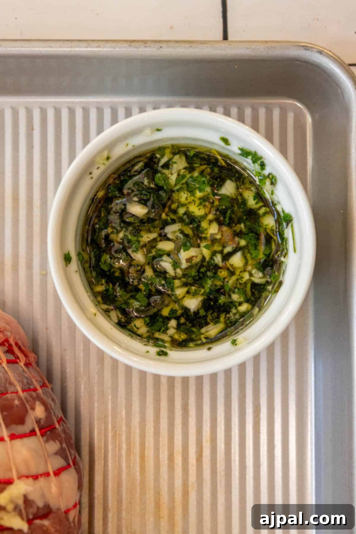 Succulent Reverse Seared Lamb Leg 5 The leg of lamb fully coated with a vibrant herb and garlic marinade, ready for its initial slow roast.
