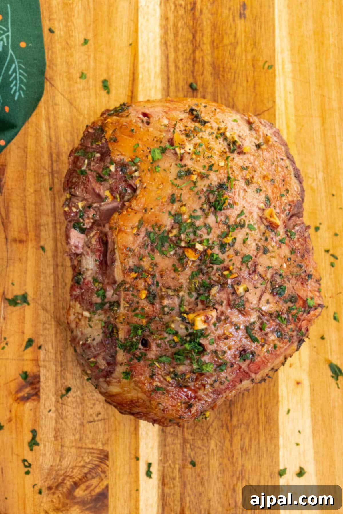Succulent Reverse Seared Lamb Leg 8 The golden-brown, seared leg of lamb on a wooden cutting board, showcasing its crispy exterior after the reverse sear.