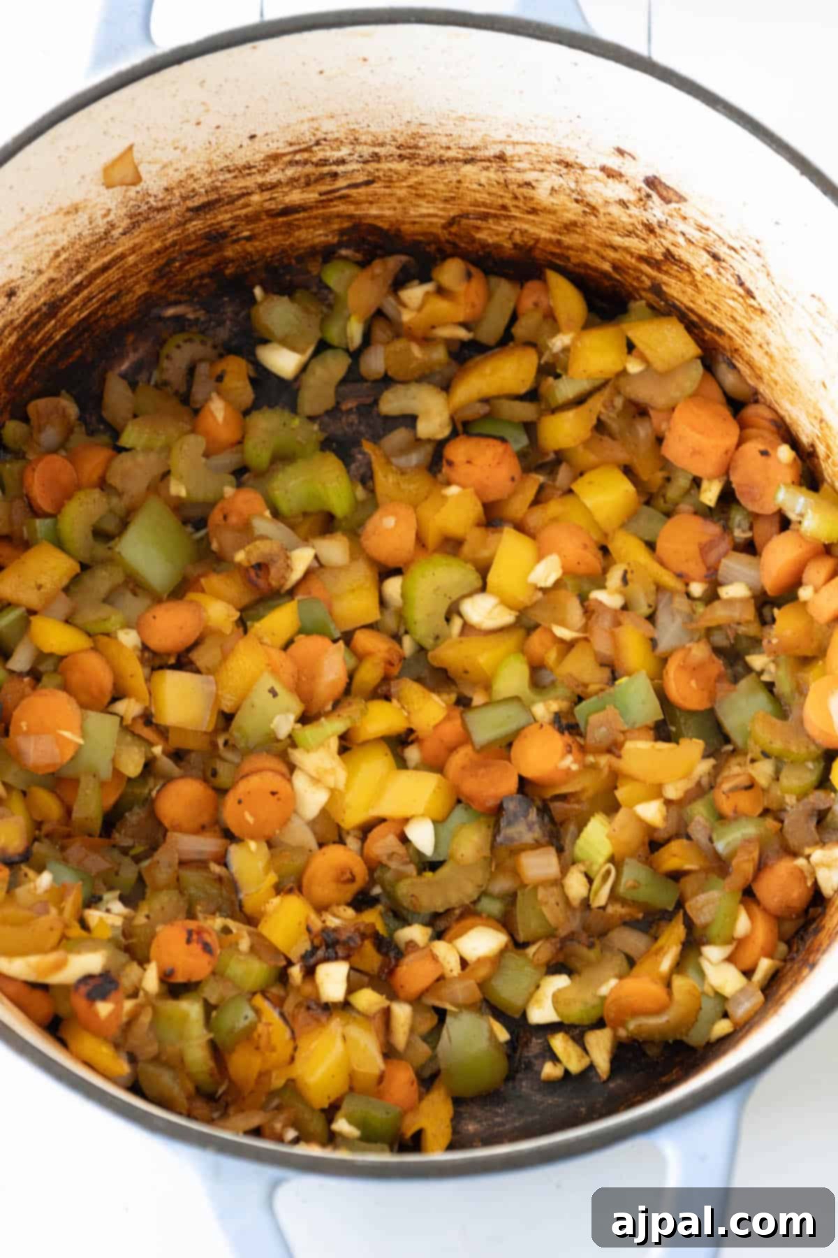 A pot of spicy beef stew actively simmering on a stovetop burner, steam gently rising.